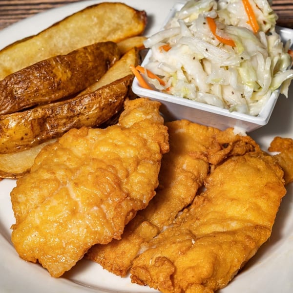 Captain Brian's fried fish and potato wedges with a side of coleslaw on a white plate.