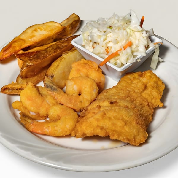 Captain Brian's fried fish and shrimp platter with potato wedges and coleslaw on a white plate.